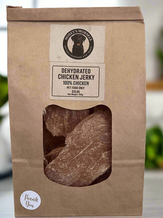 Kraft paper packaging of dehydrated chicken jerky with a clear window on a gray surface.