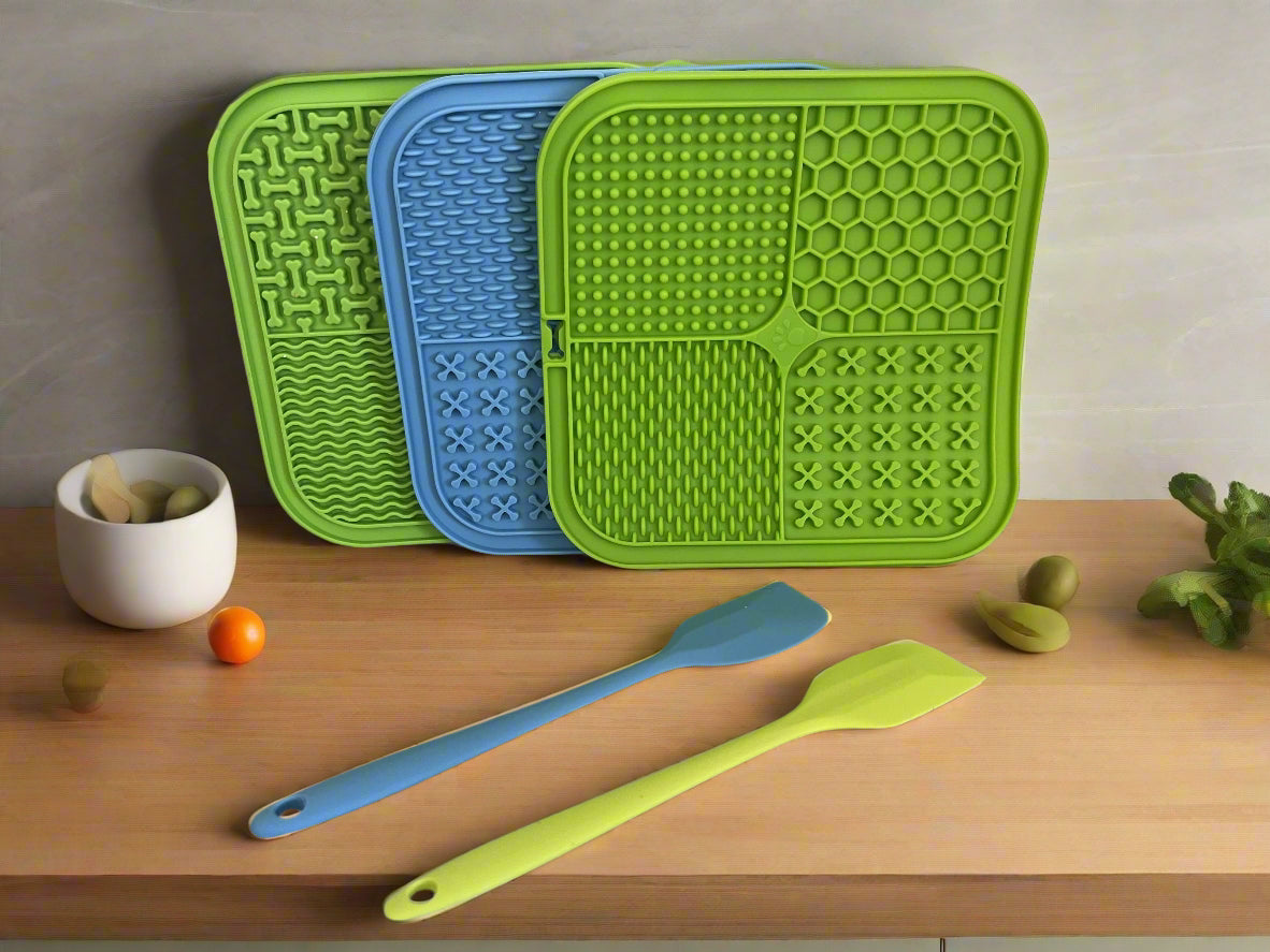 Three silicone mats in green, blue, and another green pattern on a kitchen counter.